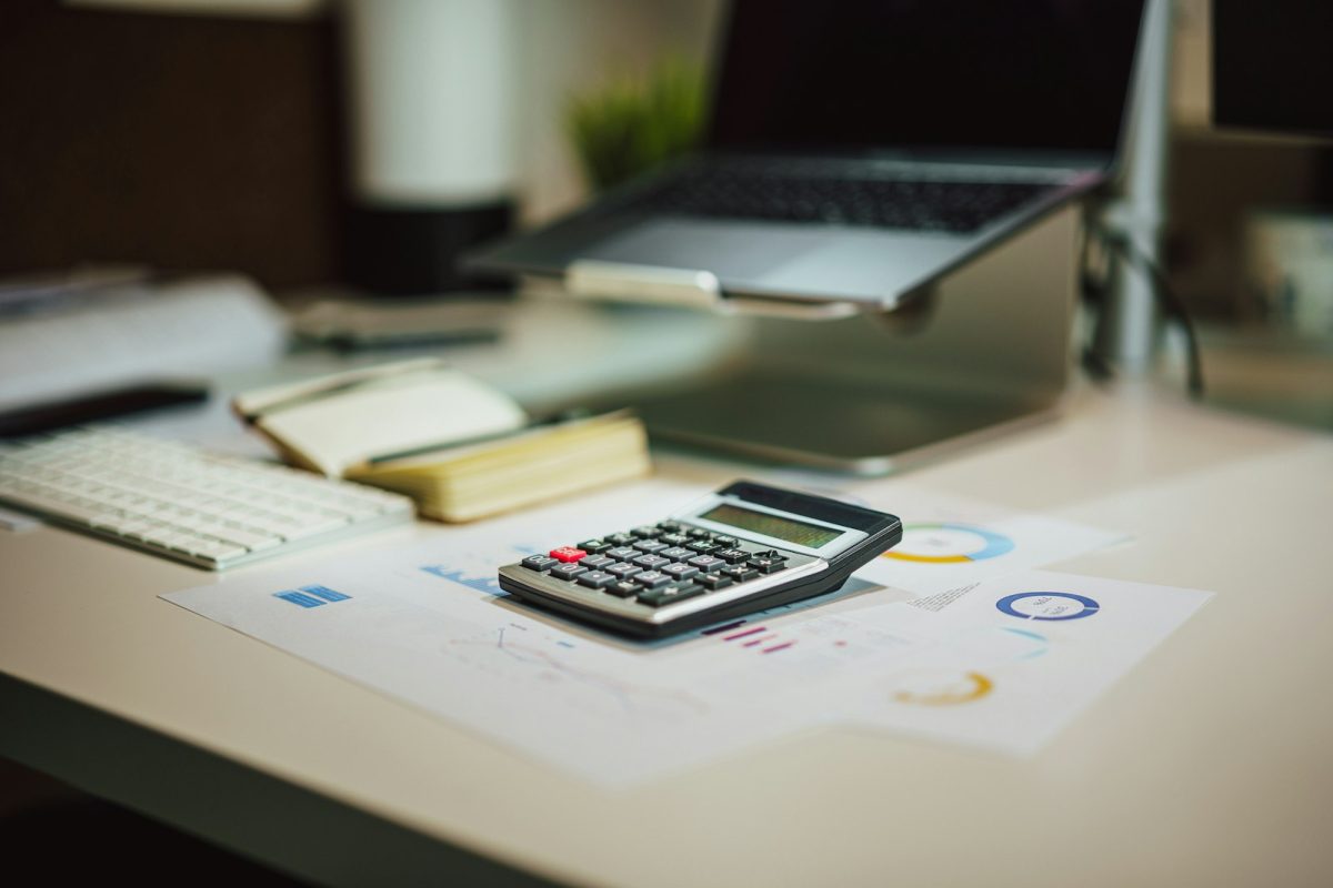 Financial reports, charts and a calculator on an auditor’s desk