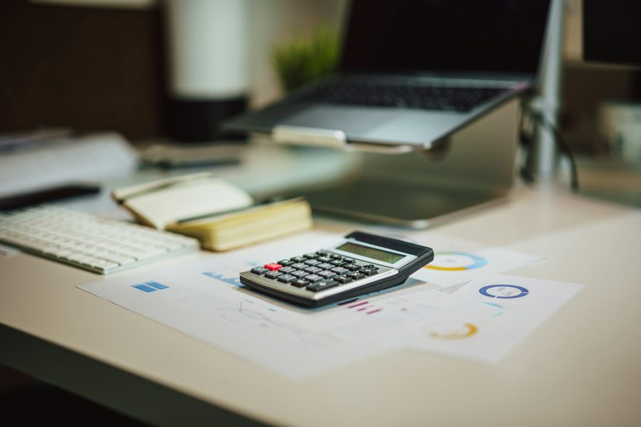 Financial reports, charts and a calculator on an auditor’s desk