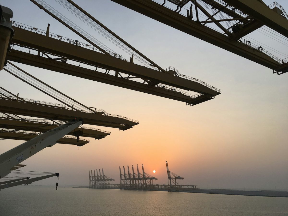 Container port cranes at sunset