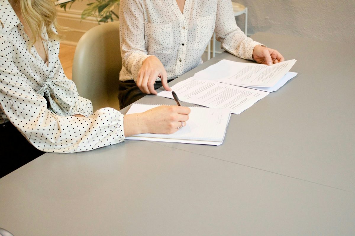 An advisor reviewing and signing financial documents with a client