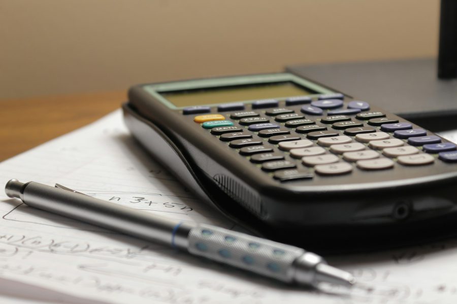 Calculator and pen on tax working papers